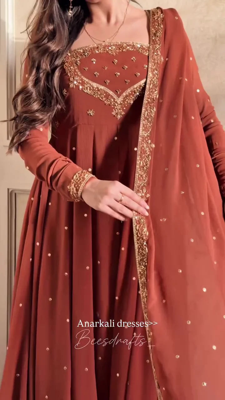 Cascading Layers of Terracotta Fabric Detailed with Intricate Yoke Embroidery and Scattered Motifs